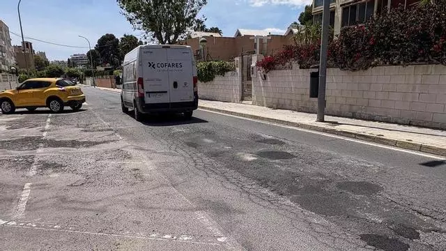 Pavimento en mal estado y caravanas estacionadas en la via pública