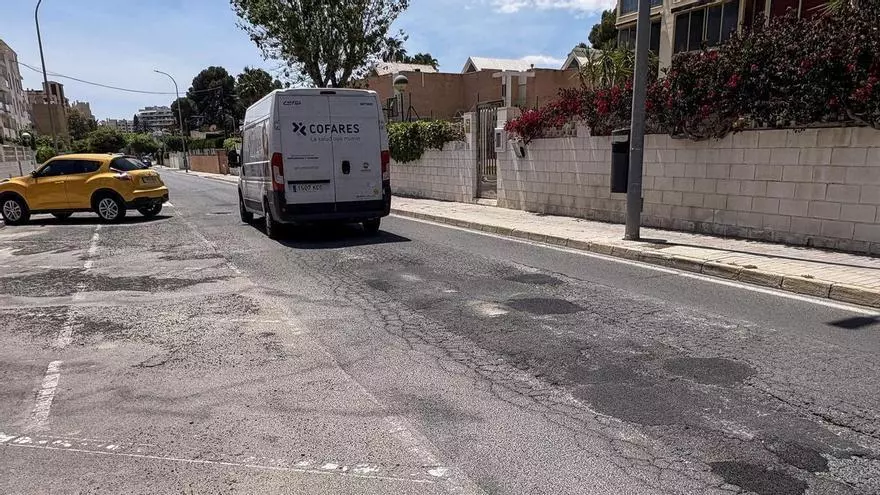 Pavimento en mal estado y caravanas estacionadas en la via pública