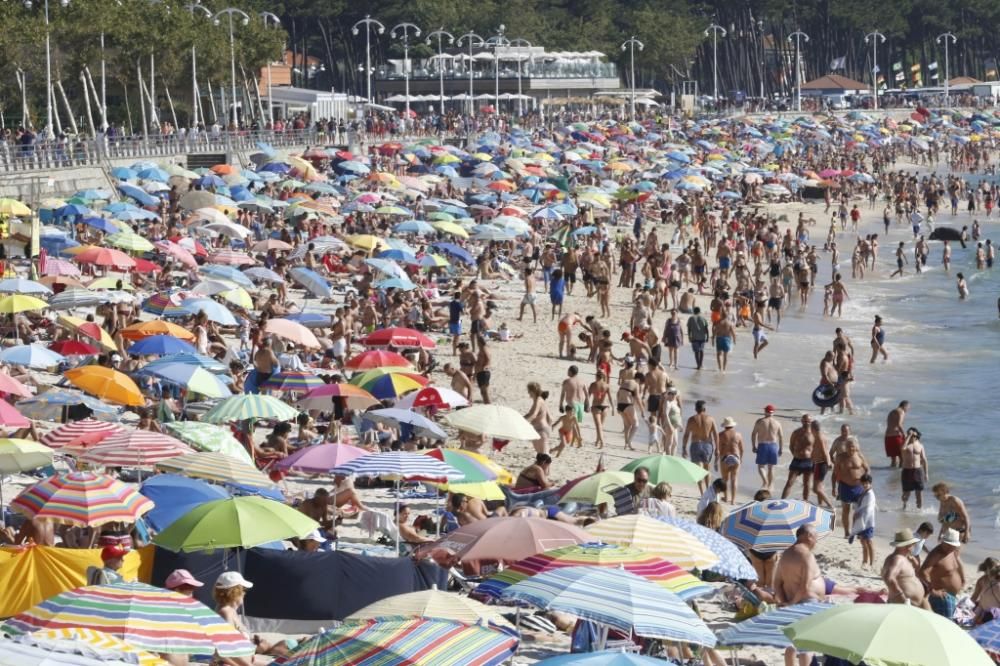 El buen tiempo anima a los bañistas en la playa de Samil