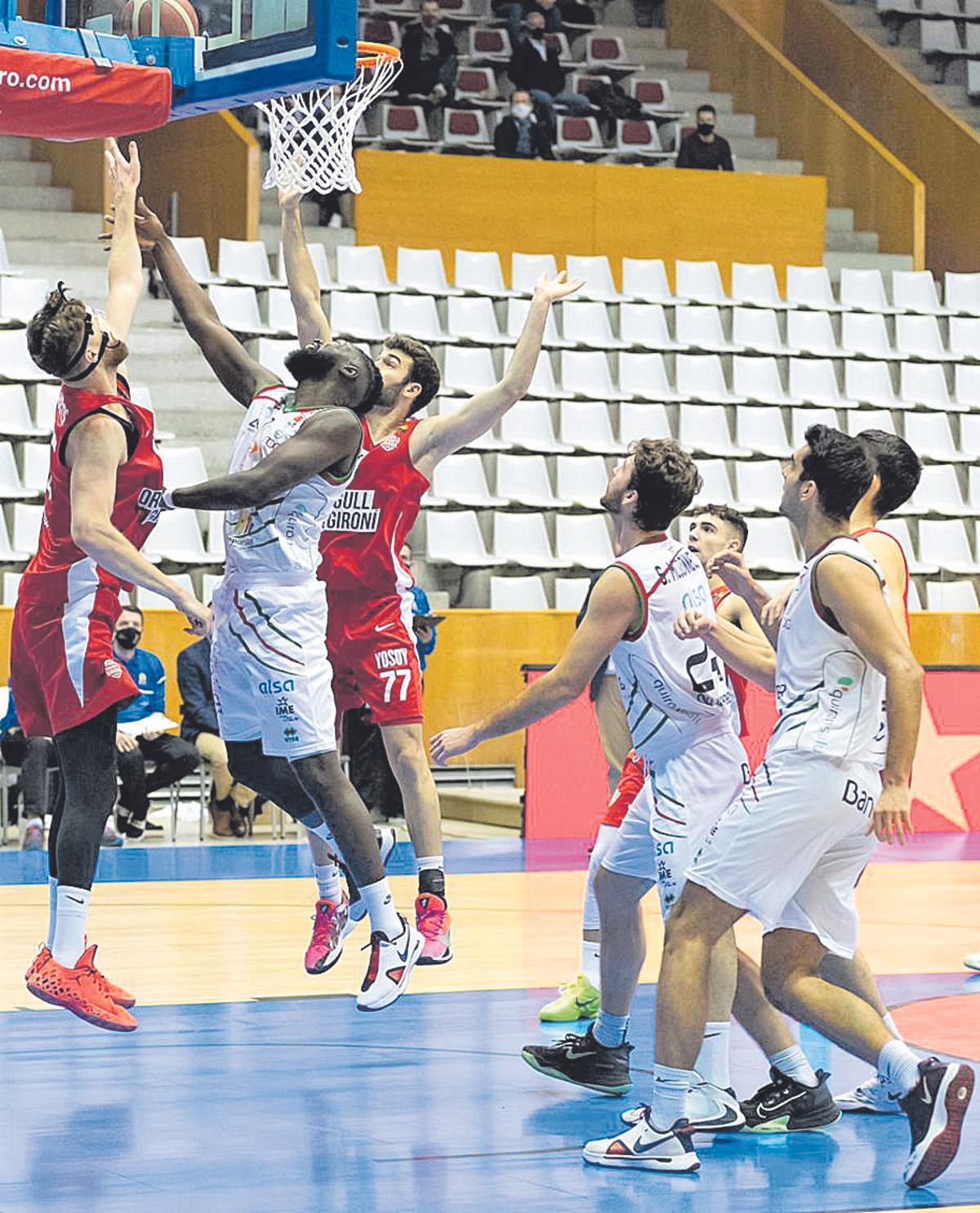 Jawara lanza a canasta entre dos rivales en Girona.