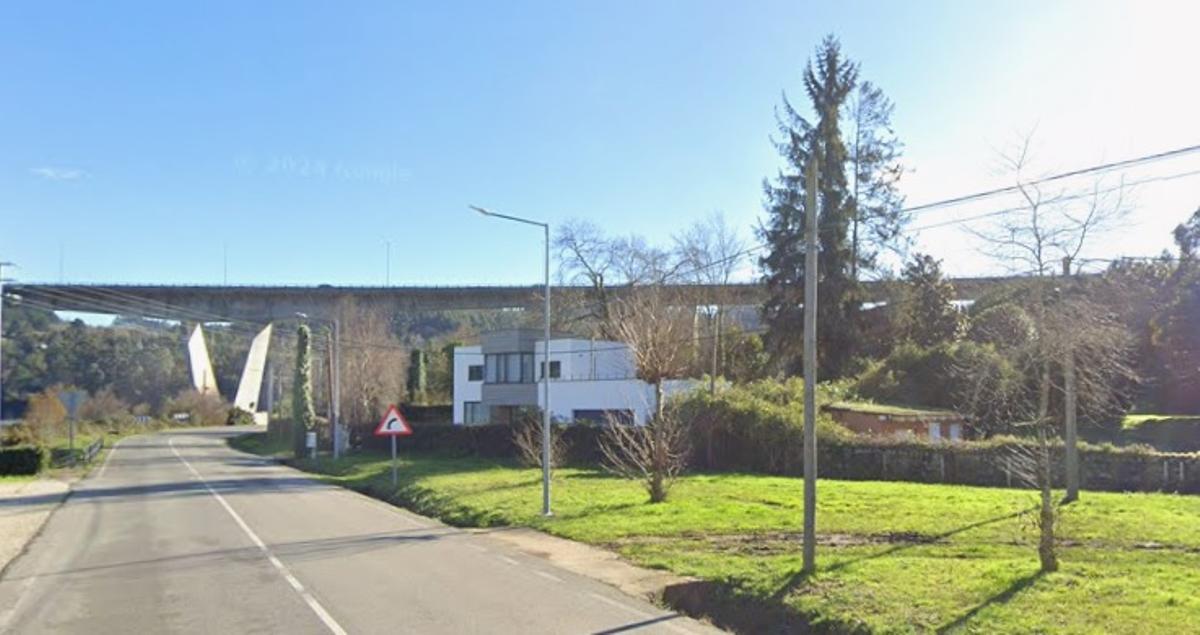 Viviendas del lugar de Mariñán y, al fondo, el viaducto de la autopista AP-9.
