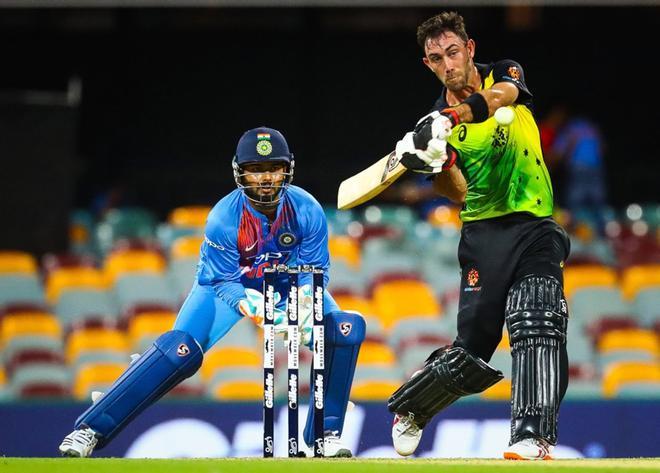 El bateador australiano Glenn Maxwell (R) realiza un disparo desde la bolera de Krunal Pandya de la India durante el partido internacional de cricket T20 entre Australia e India en Brisbane.