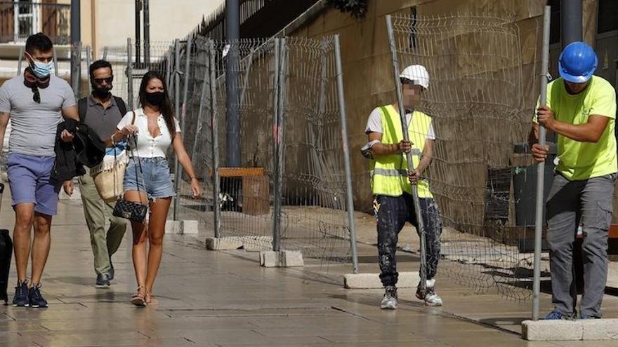 Jóvenes con mascarillas pasean por el Centro de Málaga.