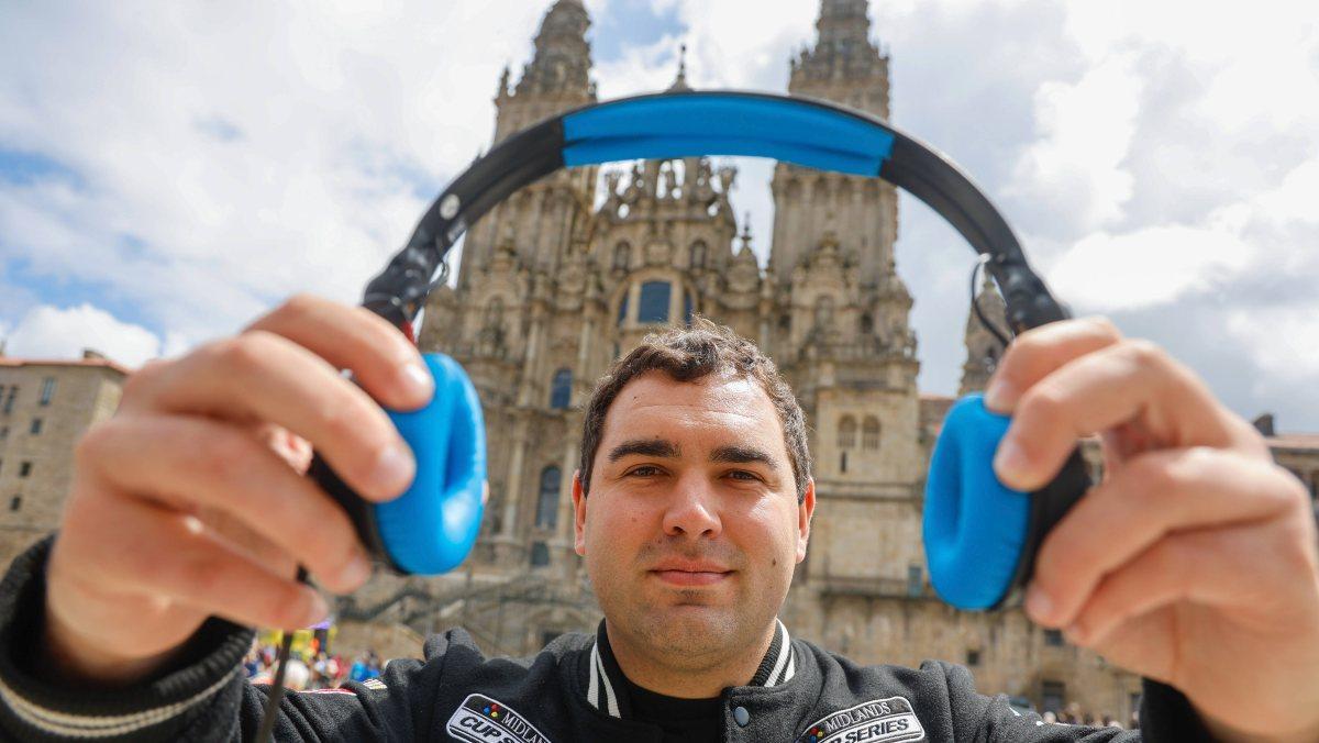 Kike Varela, dj compostelano, en el Obradoiro mostrando uno de sus auriculares en el casco histórico de Santiago.