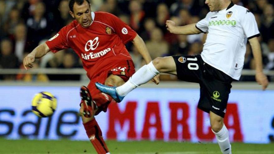 El centrocampista del Valencia Juan Mata disputa el balón al defensa del Mallorca Iván Ramis .