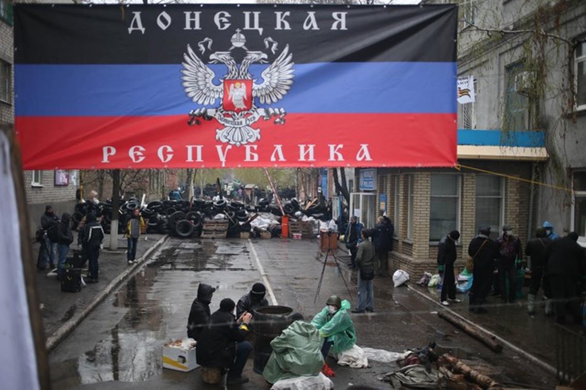 Ucraïnesos separatistes, davant una comissaria de policia i sota una pancarta que diu: ’República de Donetsk’.