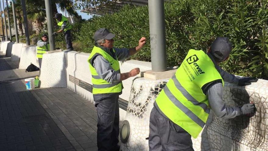 Trabajadores municipales limpiando pintadas.