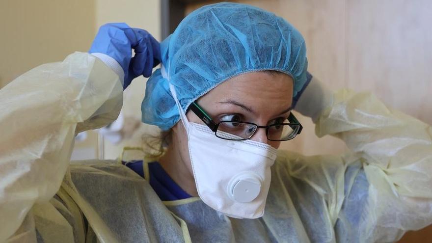 Personal sanitario se pone la mascarilla.