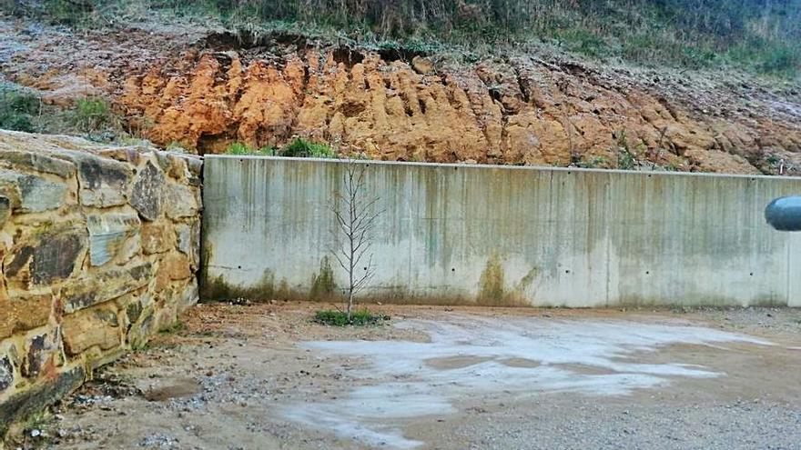 El patio lleno de barro y el talud que amenaza con desprenderse