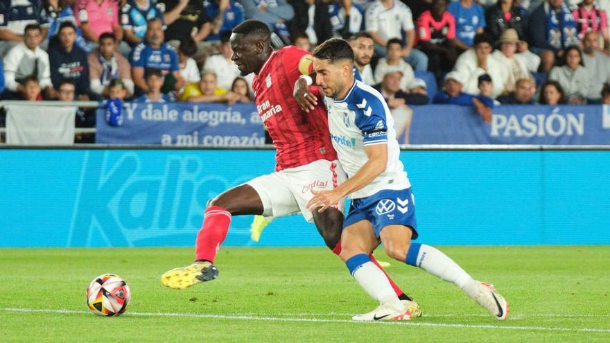 Nuke Mfulu cubre la posición ante la presión de Yann Bodiger, mediocentro del CD Tenerife, el pasado domingo en el Heliodoro.   | | CARSTEN W. LAURITSEN