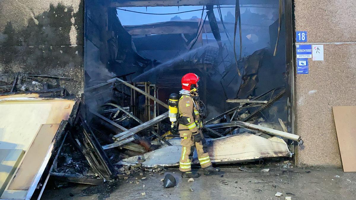 Un bombero evalúa el interior de la fábrica calcinada en Bueu.