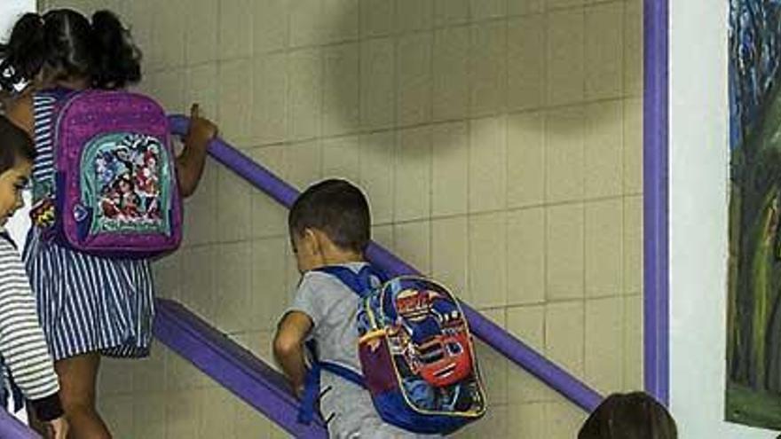 Varios niños suben por las escaleras en su colegio.