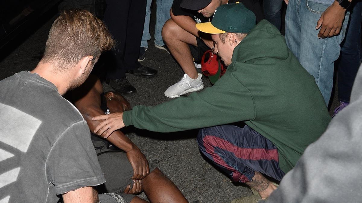 Justin Bieber, ayudando al paparazzi al que previamente había atropellado a la salida de una iglesia en Hollywood.