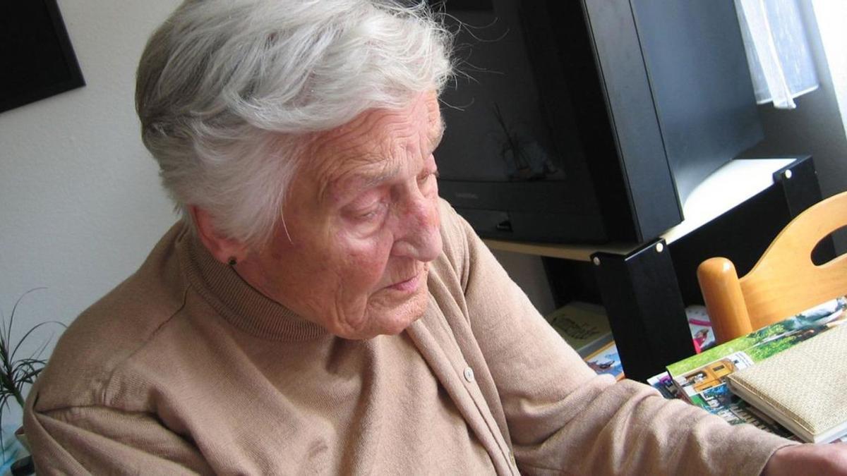 Una dona amb Alzheimer fent exercicis per potenciar la memòria a casa seva.