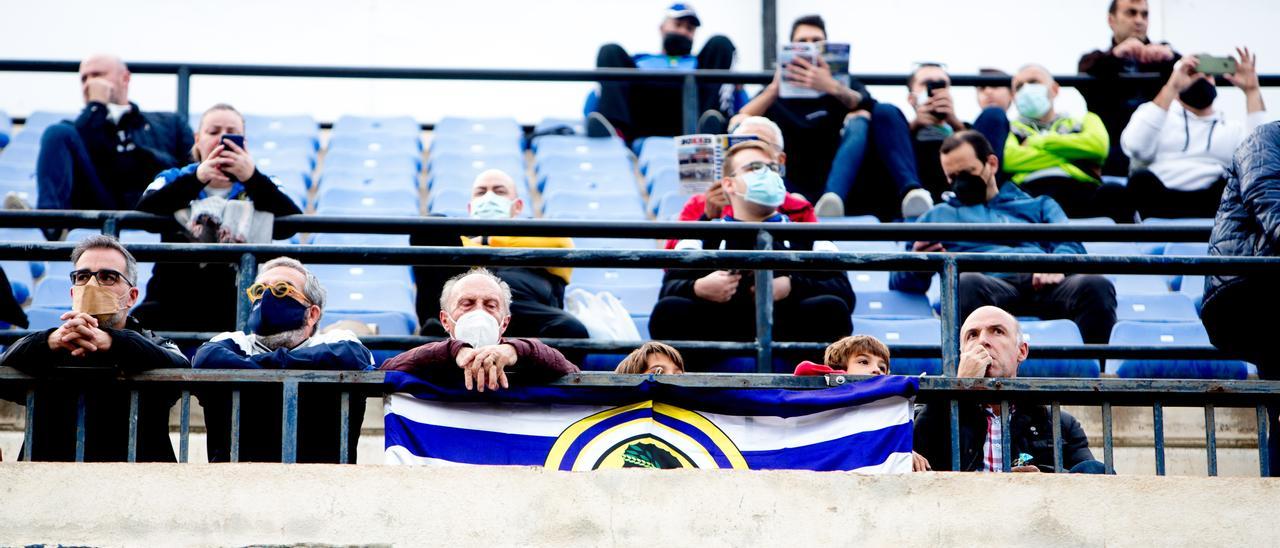 Aficionados del Hércules siguen un partido en Alicante en una de las muchas zonas en las que la mayoría de las butacas están libres pese a ser localidades muy demandadas.