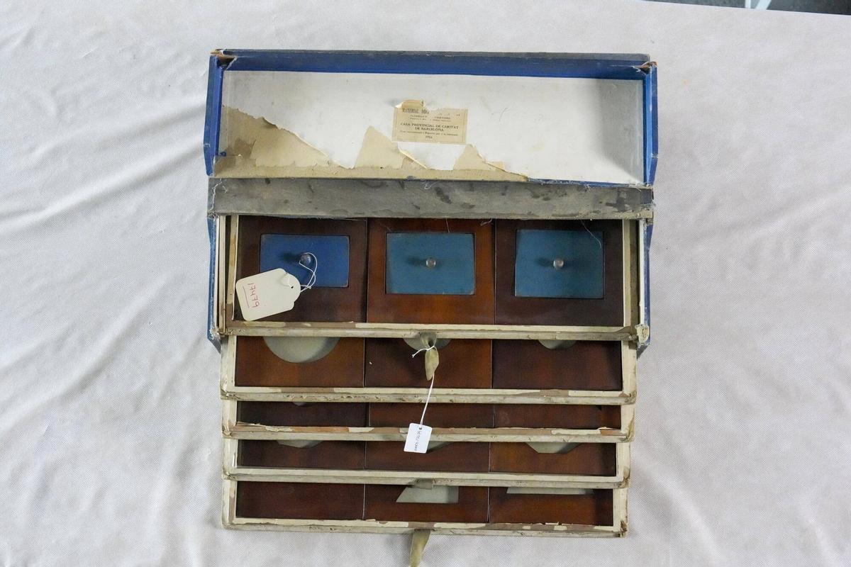 Cajonera de cartón con plantillas de madera de figuras geométricas, de inicios del siglo XX y metodología Montessori, de la colección de material escolar del Museu d'Història de Barcelona