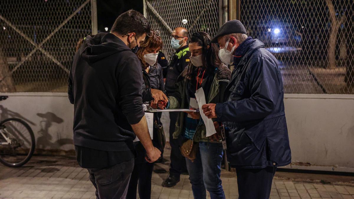 Un grupo de voluntarios anotan en un mapa las personas que se han encontrando durmiendo en la calle del barrio de Santa Eulalia (L'Hospitalet)