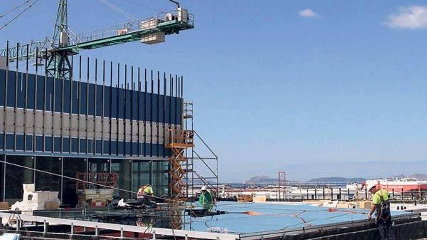 Varios operarios trabajan en la terraza-mirador del Auditorio, con las Islas Cíes al fondo //