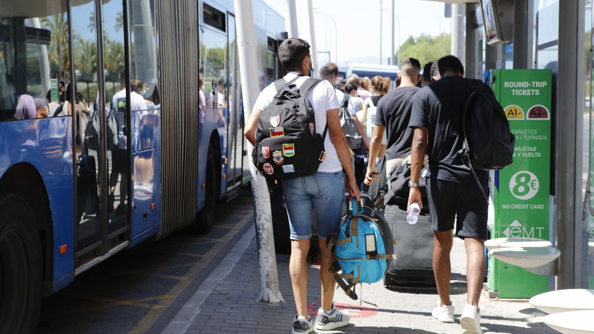 Urlauber am Flughafen Mallorca stehen Schlange, um in einen Bus einzusteigen.