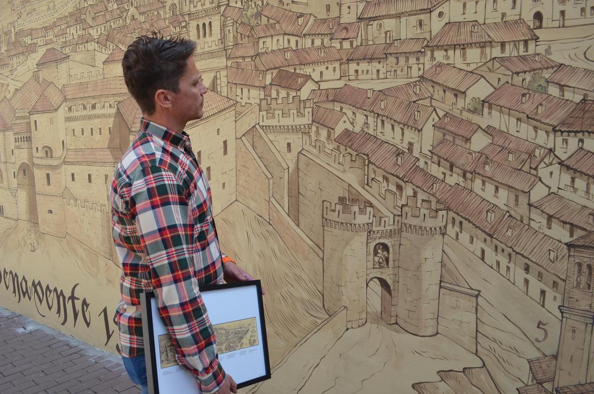 El concejal de Turismo observando la ciudad medieval estampada en el mural.