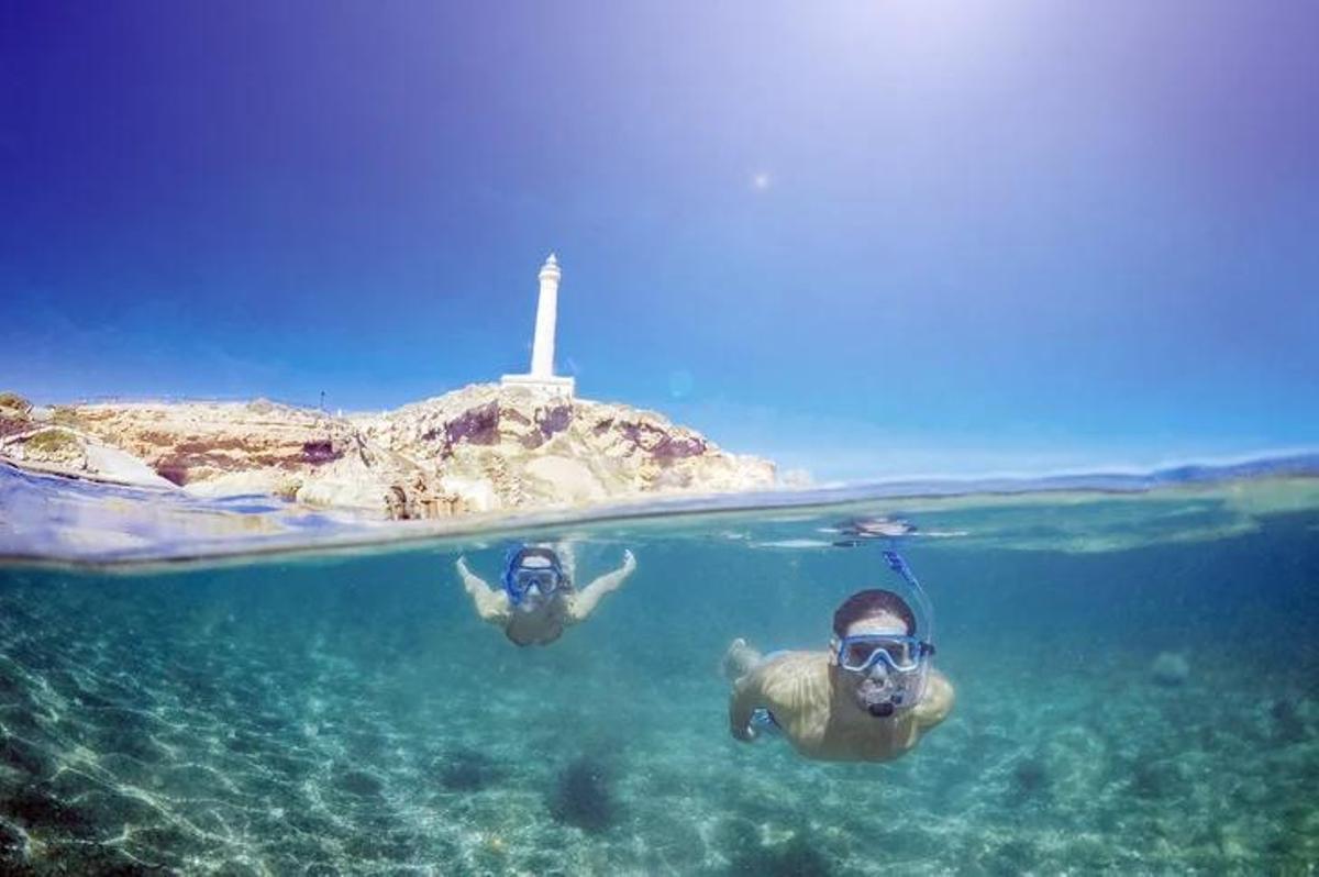 Dos personas practican esnórquel en las aguas del faro de Cabo de Palos
