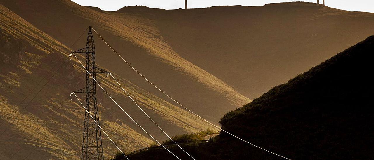 Atardecer en Belmonte, con una línea eléctrica y al fondo eólicos. | Miki López