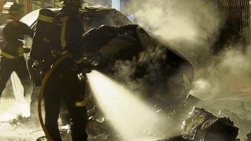 Los bomberos, durante la extinción de los contenedores quemados en Eivissa.