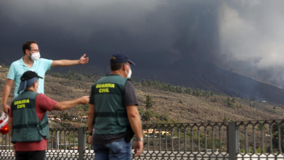 Dos guardias civiles observan la actividad volcánica en La Palma.