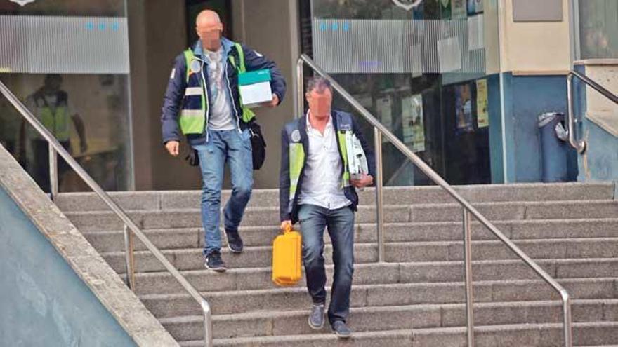 Dos agentes de la Policía Nacional se llevan documentación del Cuartel de Sant Ferran tras un registro.