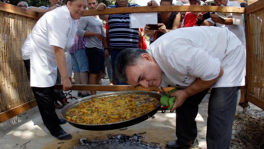 Dos cocineros ultiman una paella.