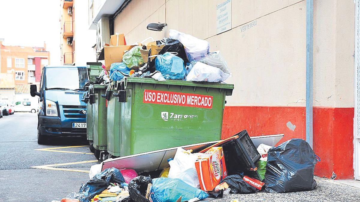 Bolsas acumuladas en un contenedor en una calle San Eloy de Zaragoza.