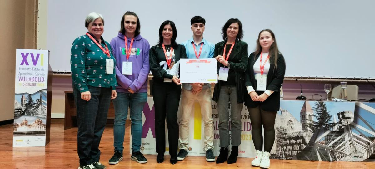 Raquel Álvarez, tercera por la izquierda, y Montserrat López Moro, segunda por la derecha, con representantes del colegio durante la entrega del premio.
