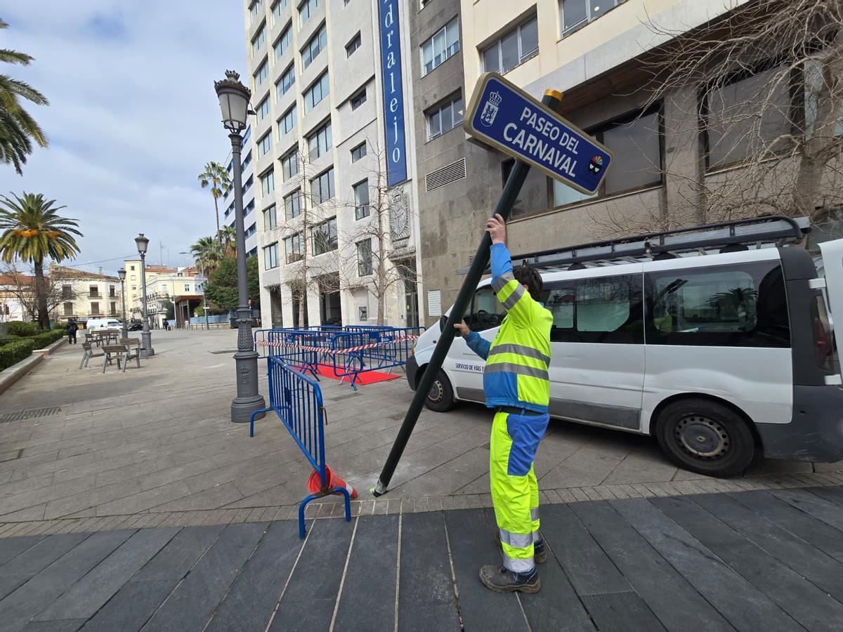 Un trabajador coloca la señal del paseo del Carnaval, en Badajoz