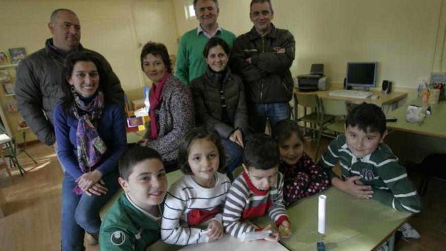 Un grupo de padres con algunos alumnos en el aula ya reparada.