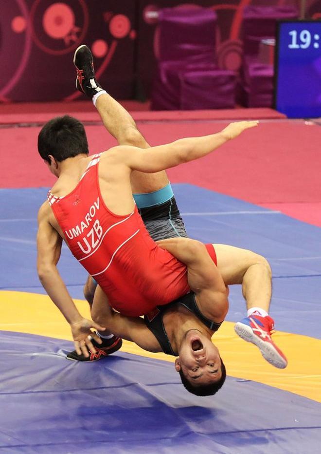 Bekhzod Umarov de Uzbekistan (rojo) compite con Renat Iliaz Uulu Renat de Kyrgyzstan durante el enfrentamiento por la medalla de bronce en la categoria Greco Romana 77kg del Campeonato Asiático de Wrestling disputado en Nueva Delhi, India.