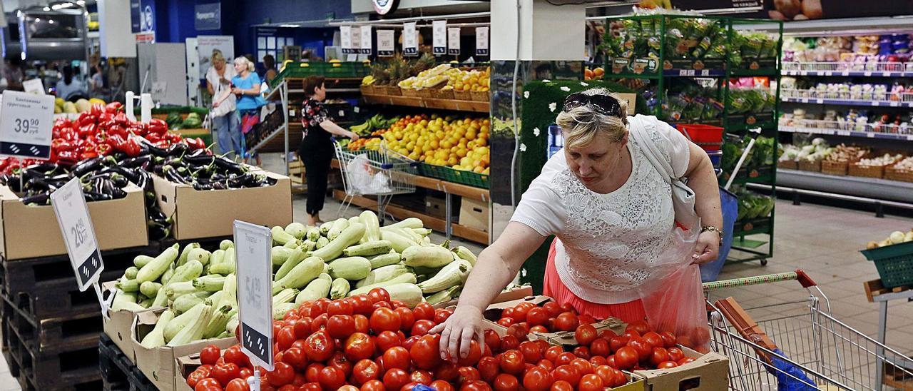Una mujer elige tomates en un supermercado repleto de frutas y hortalizas de Moscú. | EFE/YURI KOCHETKO
