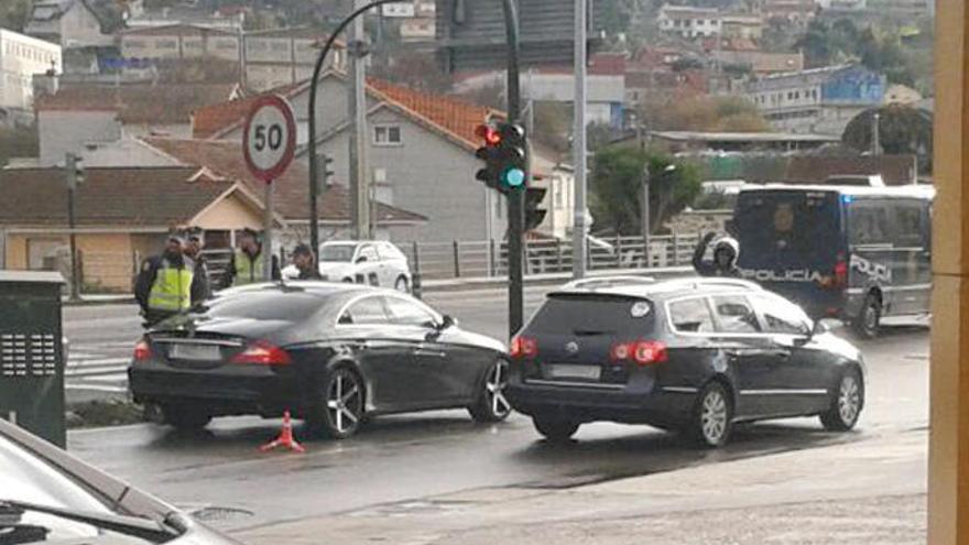 El vehículo de los detenidos, a la izquierda, rodeado de policías.