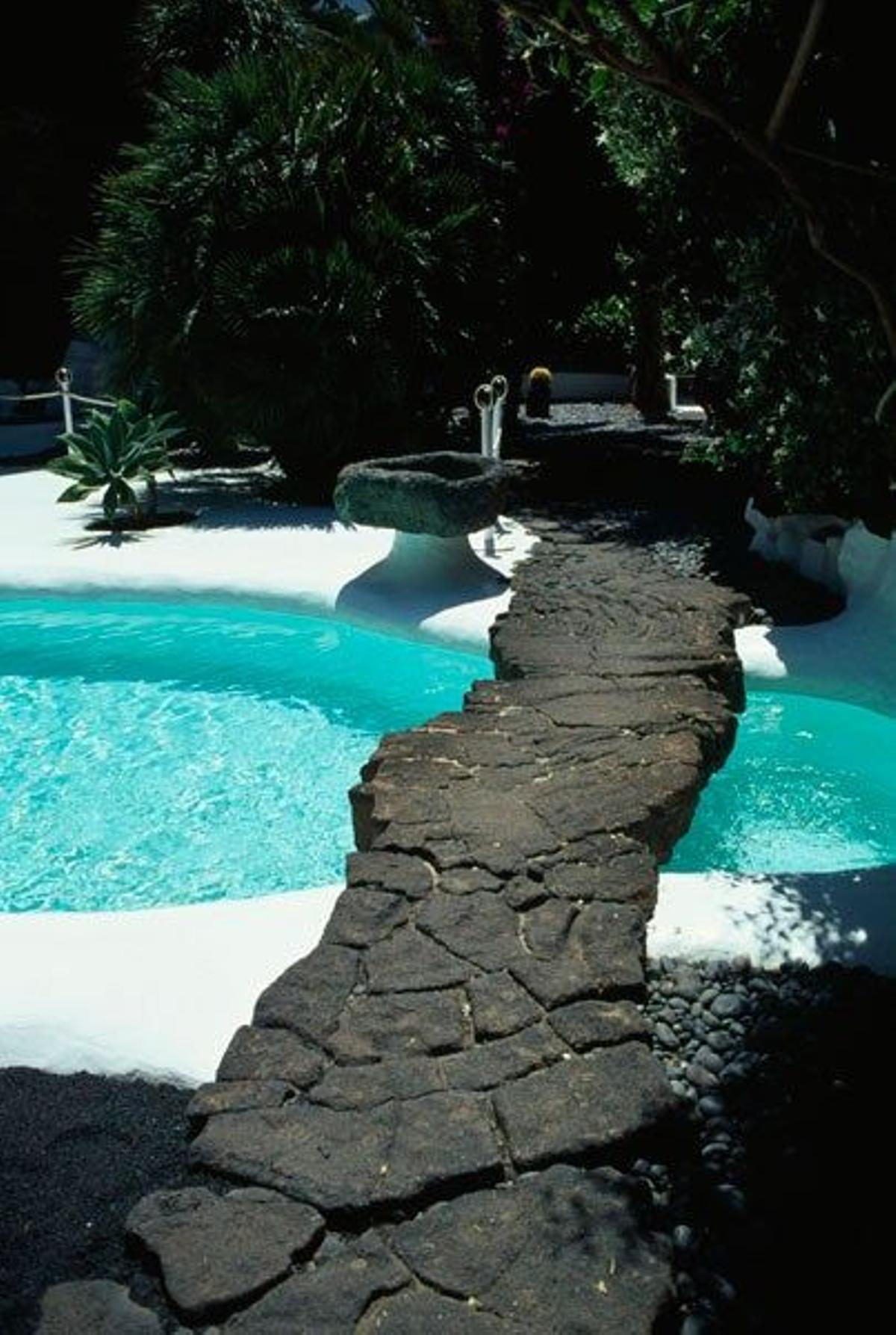Sobre la piscina de los Jameos del Agua destaca un puente hecho en lava volcánica.