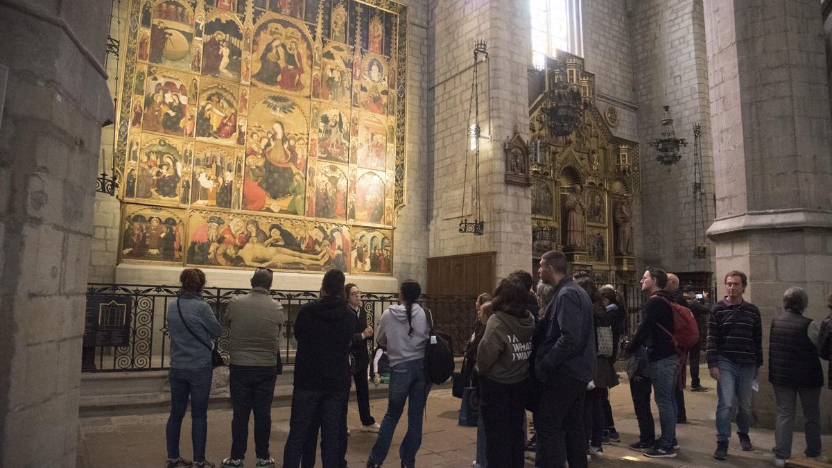 Un grup de turistes observa el retaule del Sant Esperit a la Seu de Manresa