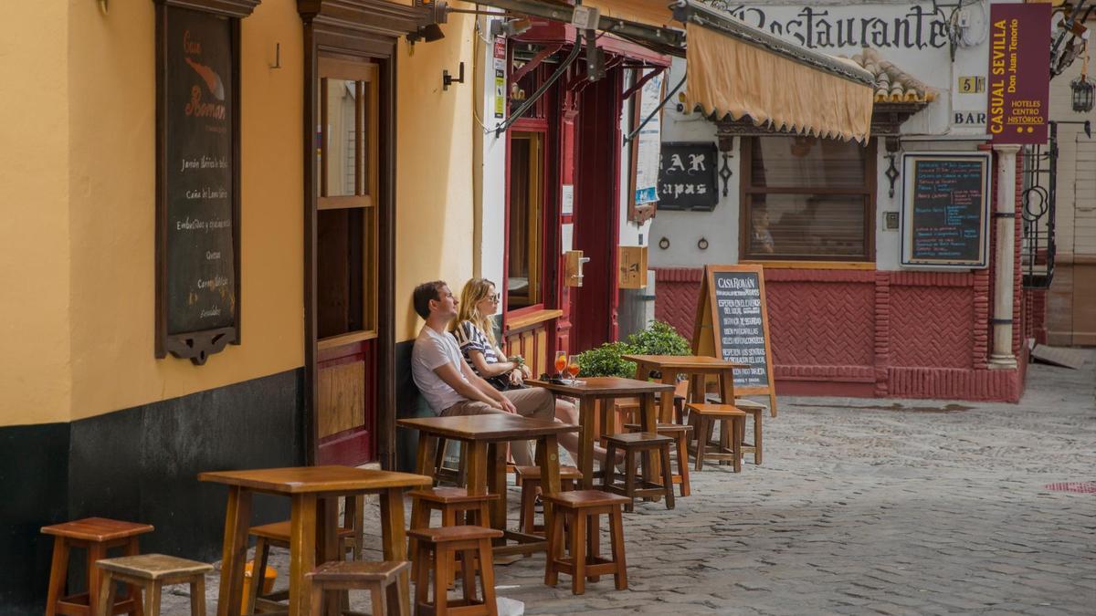 Unos turistas, en la terraza de un bar en el casco histórico de Sevilla.