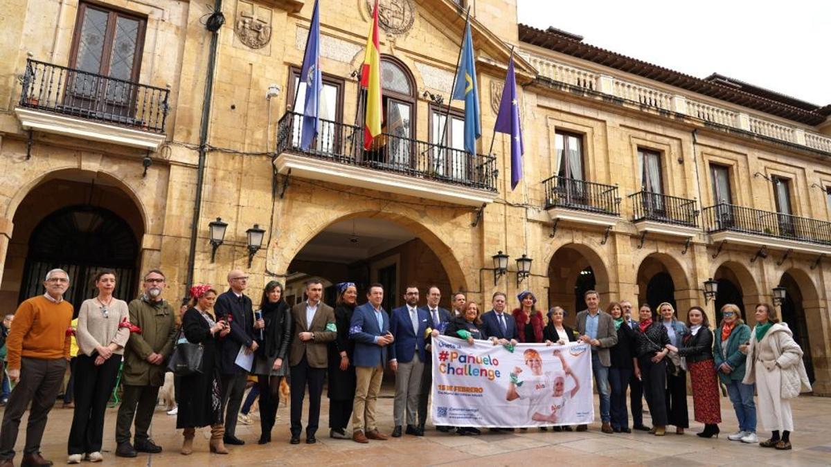 Miembros de la corporación municipal posan junto a Begoña Chaso, de la Fundación Aladina, frente al Ayuntamiento de Oviedo