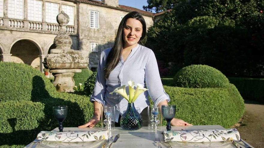 Pilar González posa tras una mesa decorada por ella, en los jardines del Pazo de Oca. // Bernabé/Luismy