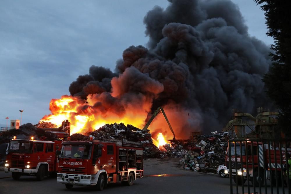 Labores de extinción del incendio de un desguace en Gijón