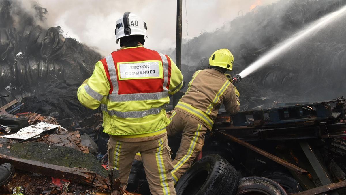 Bomberos de West Yorkshire Fire luchan contra las llamas en el cementerio de neumáticos.