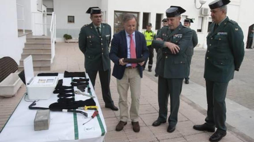 El delegado del Gobierno sostiene la trapa de alcantarilla que usaban los asaltantes, ayer.