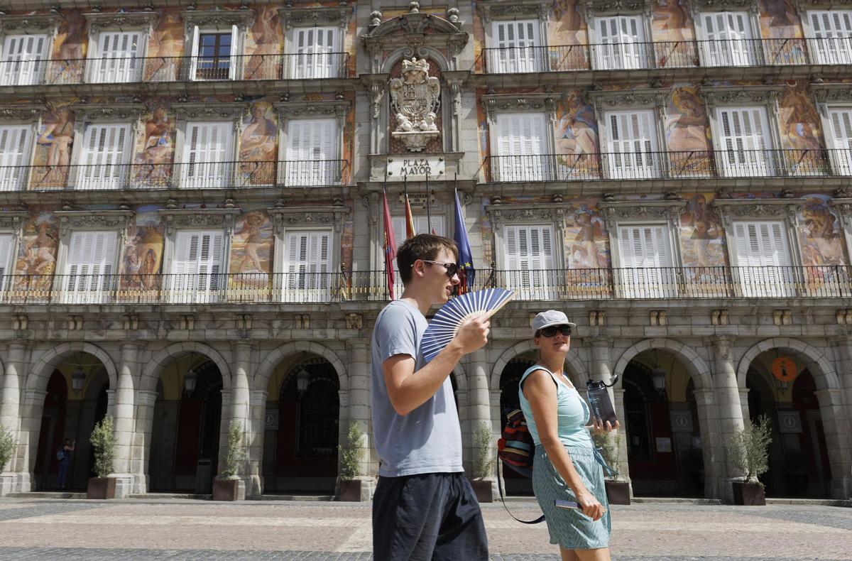 MADRID, 13/06/2022.- Unos turistas pasean por la Plaza Mayor de Madrid este lunes. La Agencia Estatal de Meteorología (Aemet) prevé en algunos puntos de la región temperaturas máximas de 41º en las zonas sur, vegas y oeste de la región, mientras que llegará a los 39 ºC en el área Metropolitana y el Henares y alcanzará los 36 ºC en la sierra. La Dirección General de Salud Pública de la Comunidad de Madrid mantendrá hasta el jueves la alerta 2 o alto riesgo por calor. EFE/ Sergio Pérez