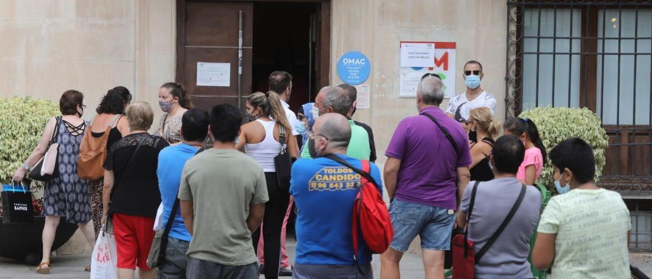 Varias personas hacen cola en la Oficina Municipal de Atención Ciudadana en Elche, en una imagen de archivo.