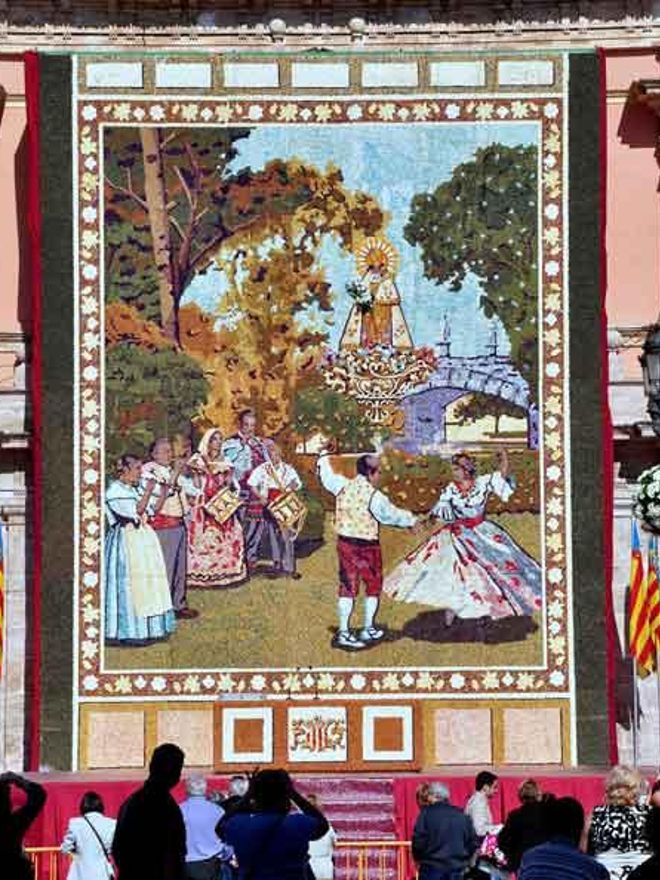 El público contempla un tapiz floral dedicado a la Virgen.