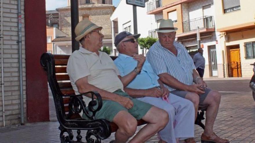 Un grupo de personas mayores sentadas en un banco.
