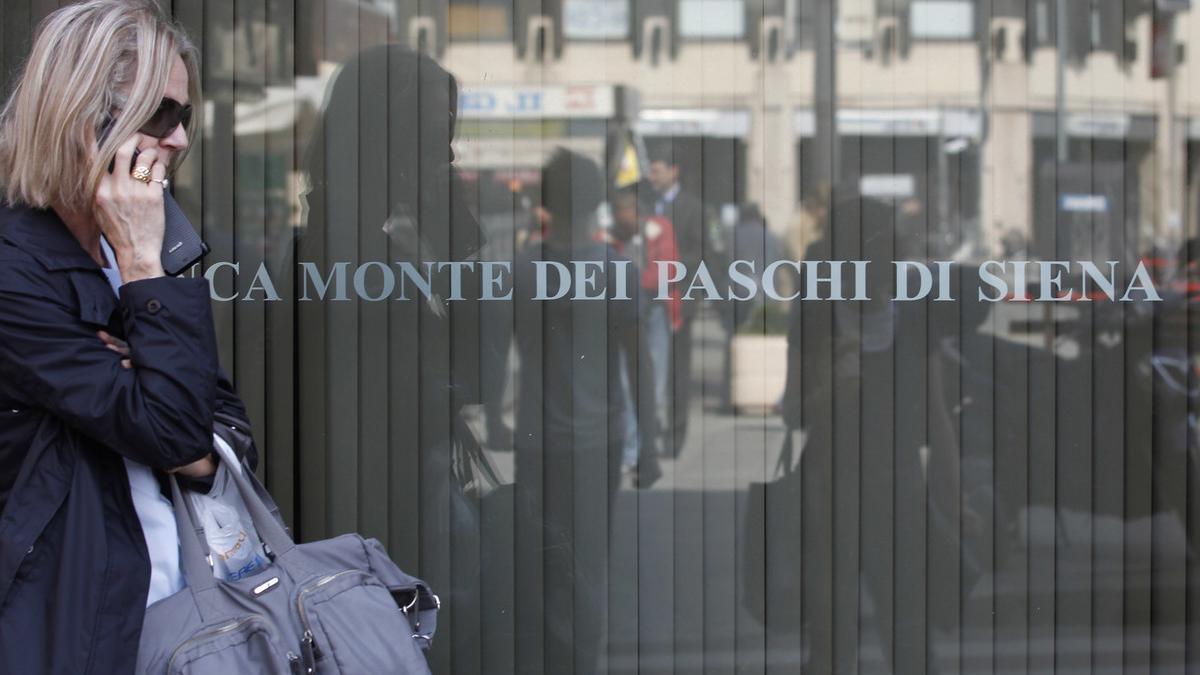 Una mujer pasa ante una oficina del banco Monte Dei Paschi Di Siena en Roma.